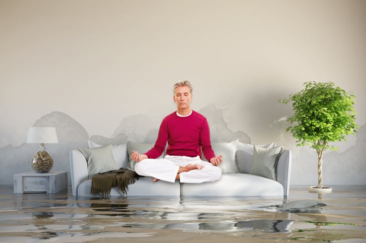 Man doing yoga in flooded living room