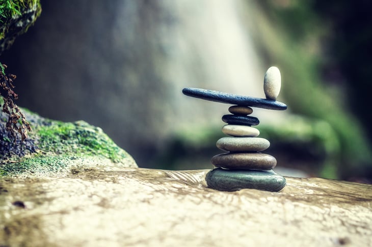 Rock cairn stacked by waterfall.