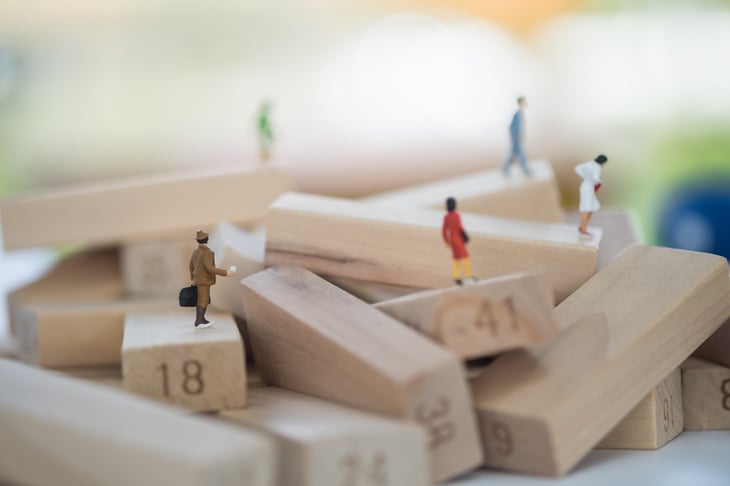 Miniature people on Jenga blocks