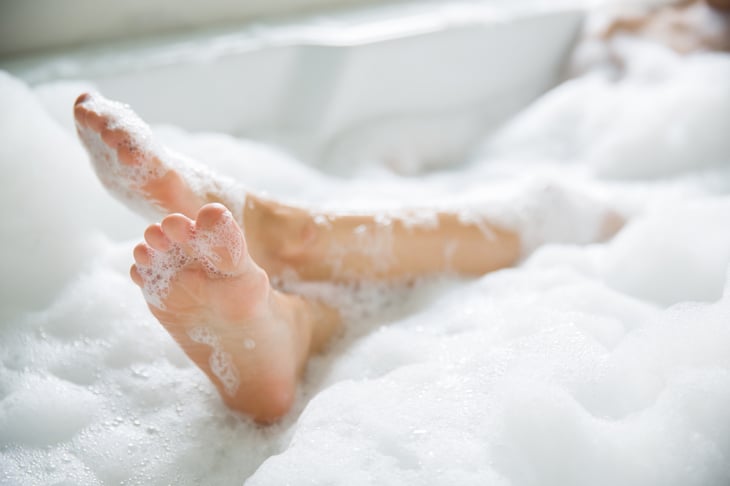 Feet covered in bubbles in a bathtub