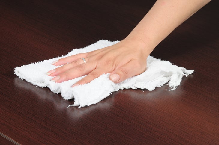 Hand with rag cleaning table top