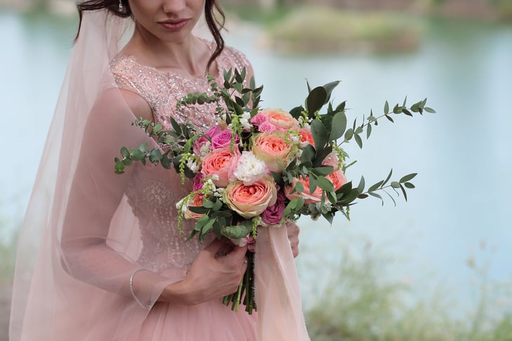Bride in a pink wedding dress holding a bouquet