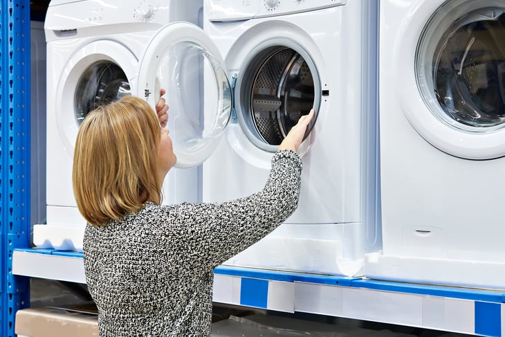 Woman looking at washing machines.