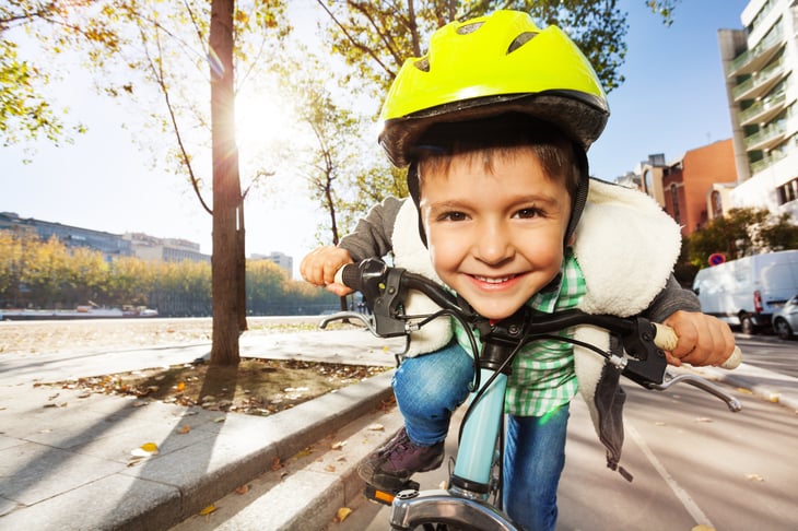 Close up of boy's face as he rides his bike.