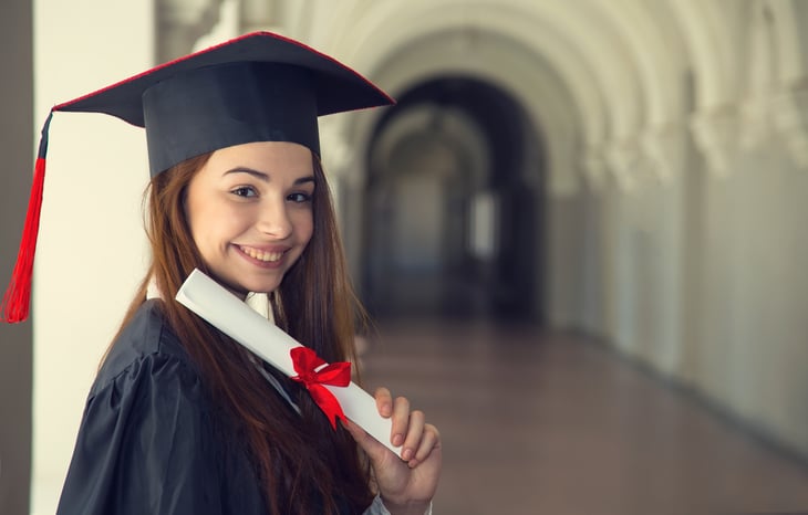 Woman in cap and gown holding a diploma