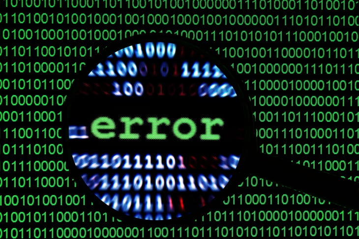 Computer code "error" viewed through magnifying glass.