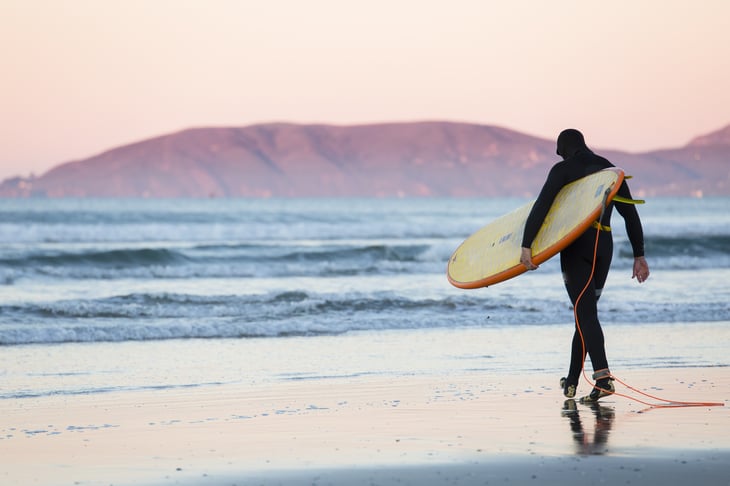 Surfer walking on Pismo Beach