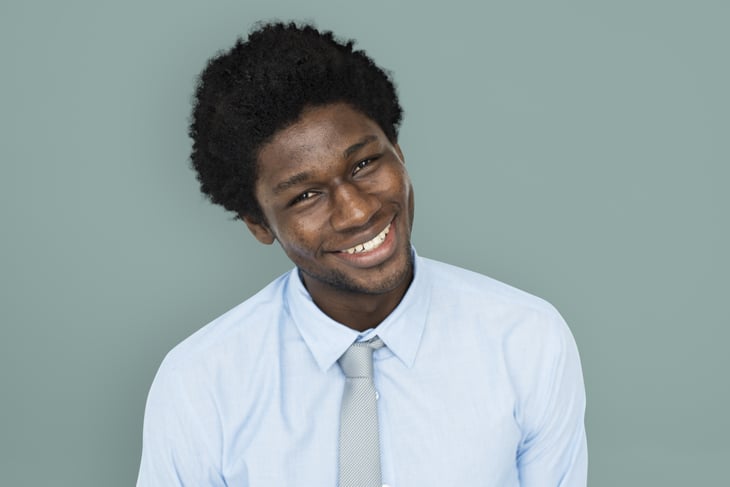 Young African American man with head tilted, smiling.