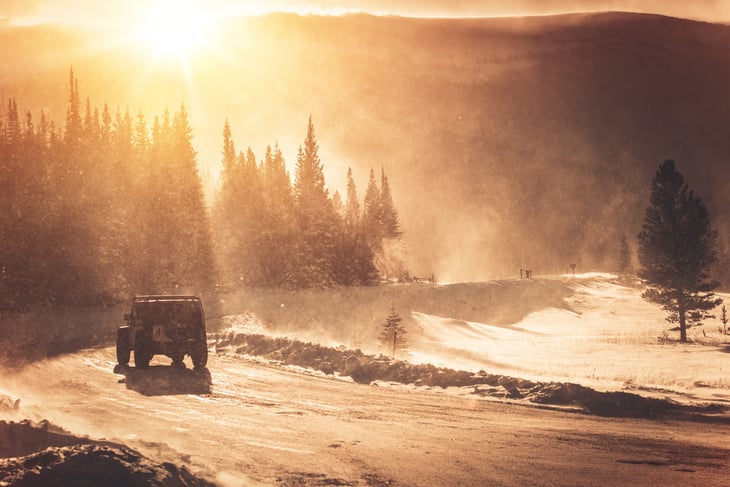 Jeep driving on mountain road in winter