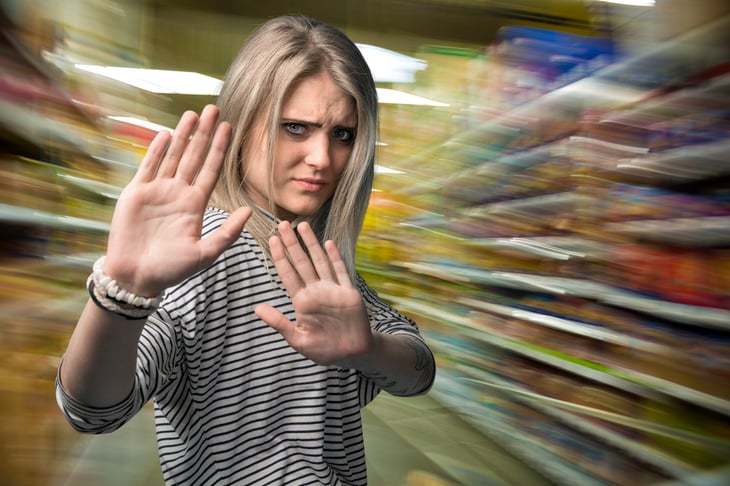 Woman in store, in defensive position.
