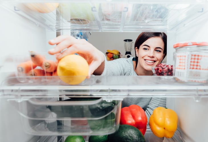 Woman reaching in refrigerator.