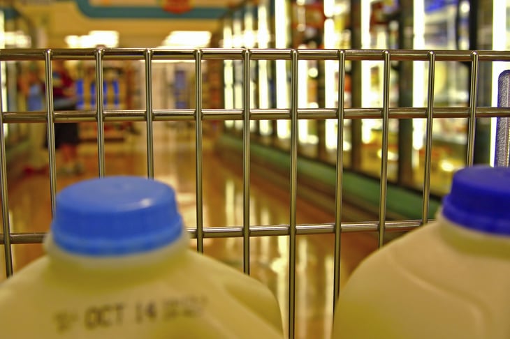 Milk jugs in shopping cart.