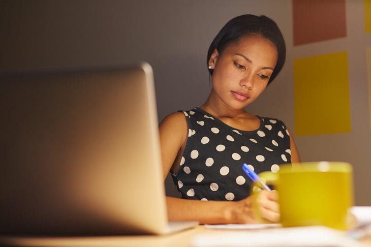 Young woman working at desk in low light
