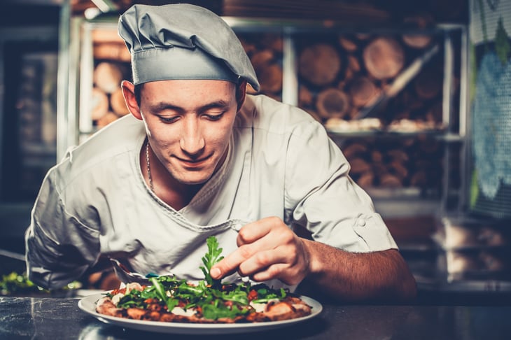 Chef looking at food.