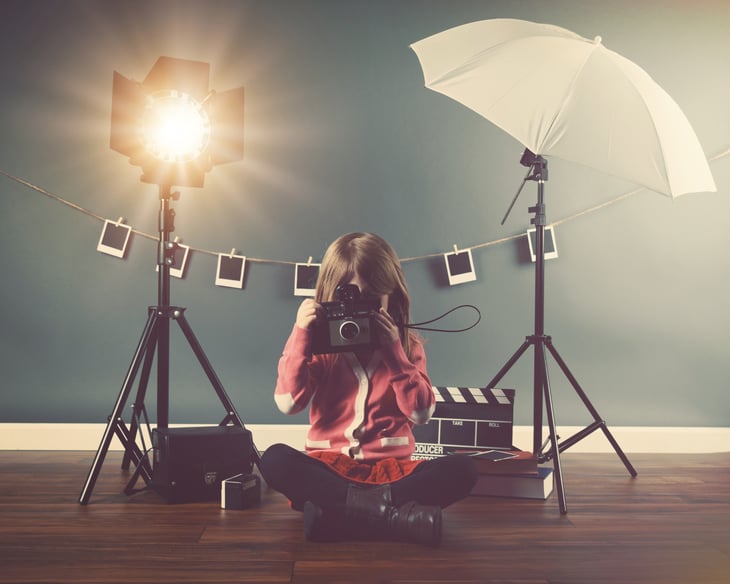 Girl with old fashioned camera and photography light set up.