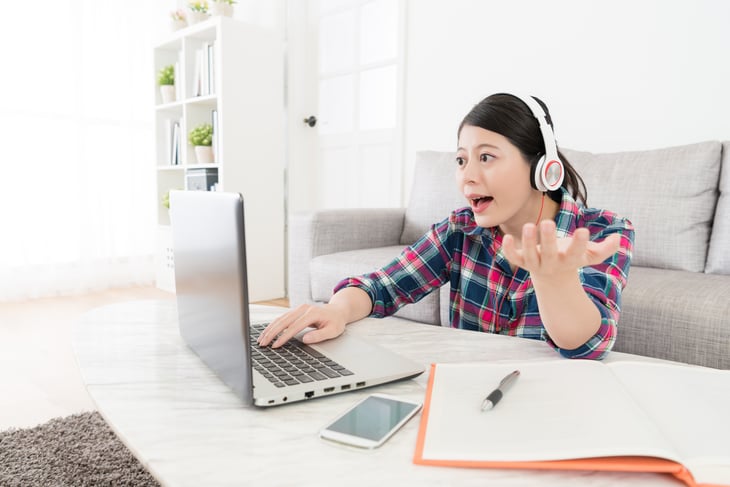 Young woman talking to a computer screen, gesturing.