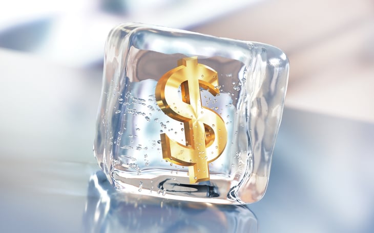 Dollar sign frozen in ice cube.