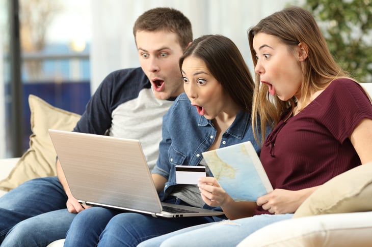 Three people surprised looking at a laptop