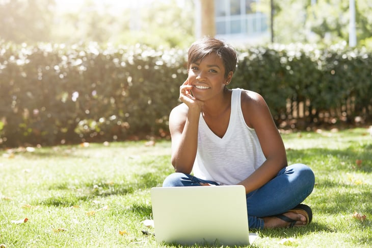 A student on her laptop sitting outside