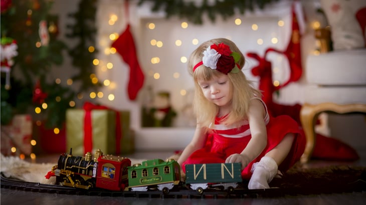 Little girl plays with toys on Christmas