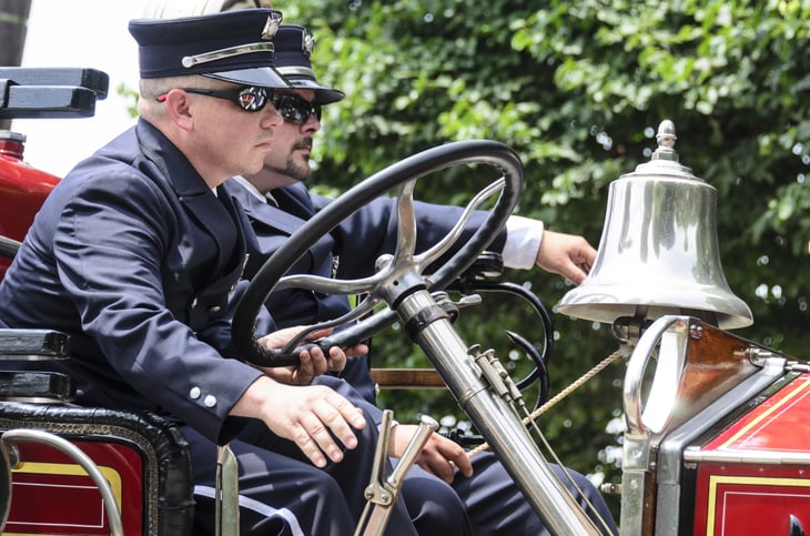 Bristol, Rhode Island, USA - July 4, 2011: Firefighters aboard antique fire engine at Independence Day parade in Bristol, Rhode Island