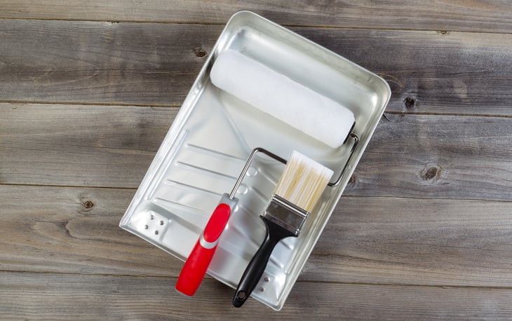Paint pan with roller and brush.