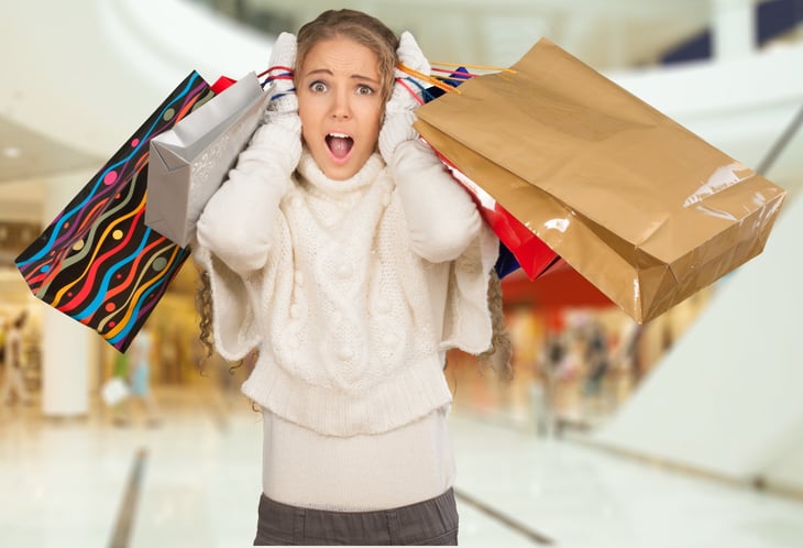 Frantic looking woman with shopping bags.