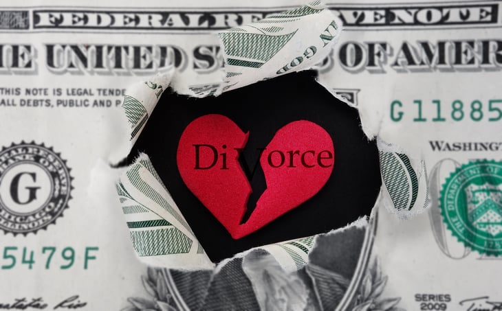 Dollar bill ripping to reveal broken heart.