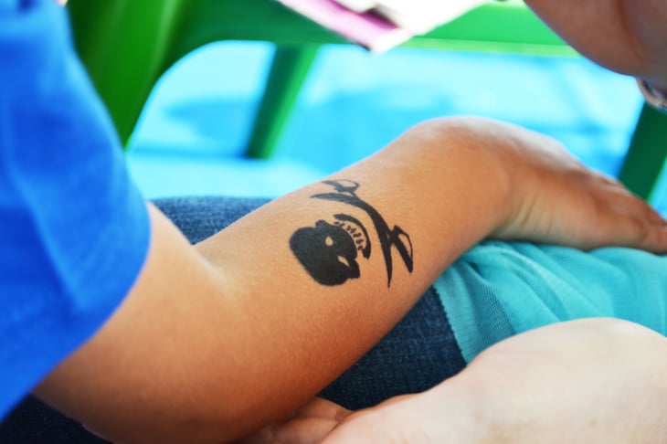 Child's arm with skull-crossbones temporary tattoo