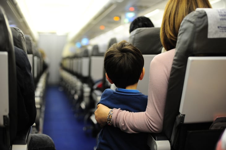 Child standing in airplane aisle