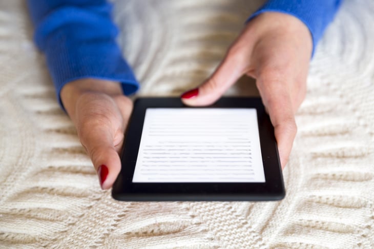 Woman reading an e-book on her bed