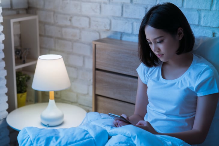 Woman using her phone in bed