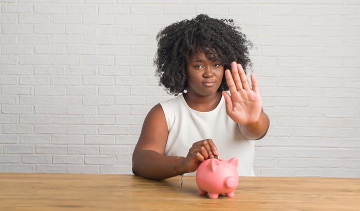 Woman protecting a piggy bank