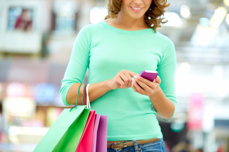 Woman with shopping bags, looking at cellphone
