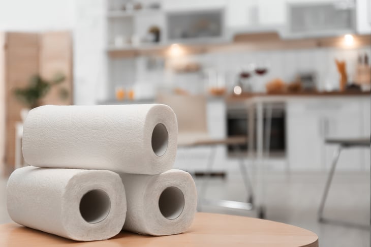 Rolls of paper towels sit on a kitchen table