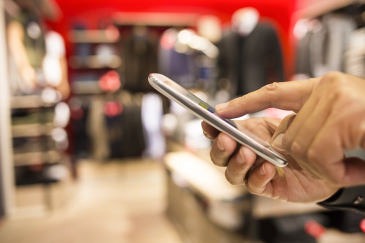 A person uses a phone app while shopping