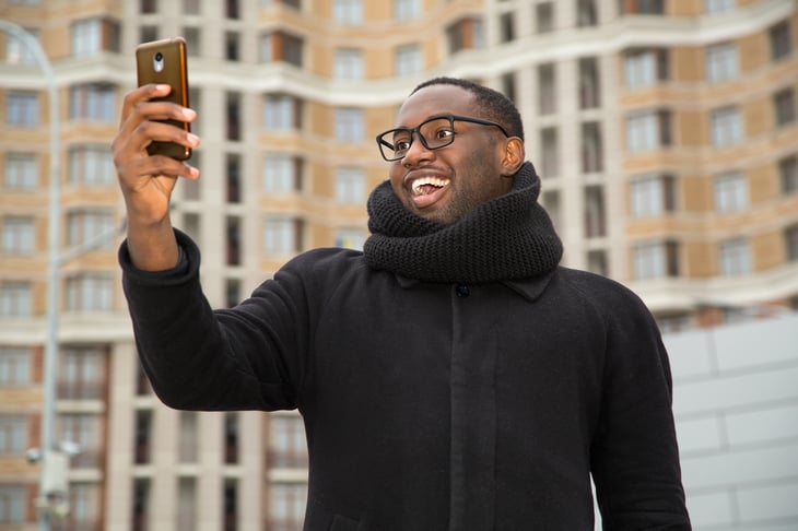 Man doing a selfie on a city street.