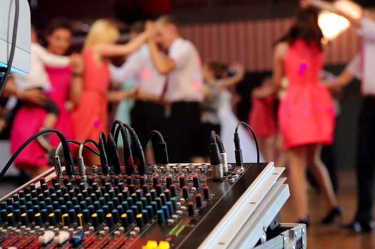 DJ/sound board set up at a wedding reception where guests dance