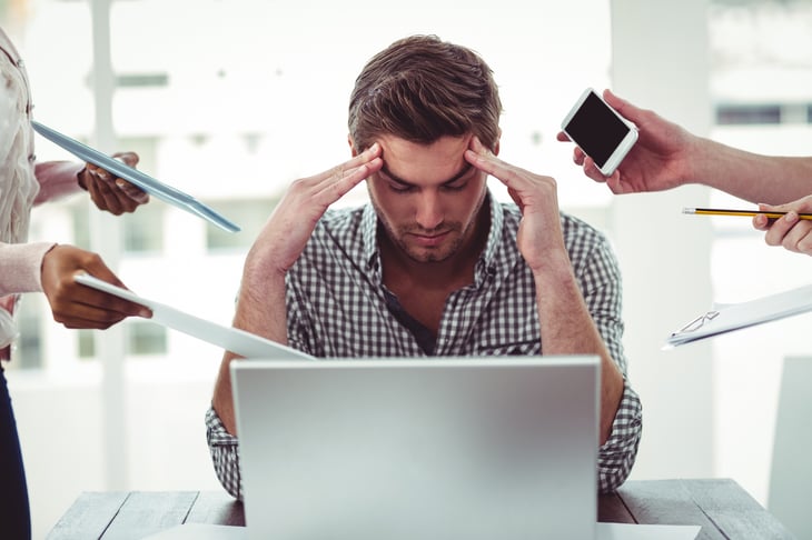 Man with his fingers to his temples, stressed.