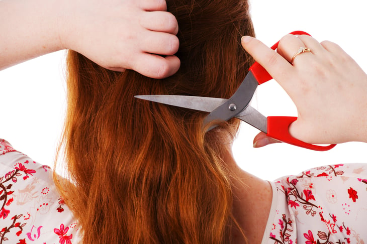 A woman cuts her own hair