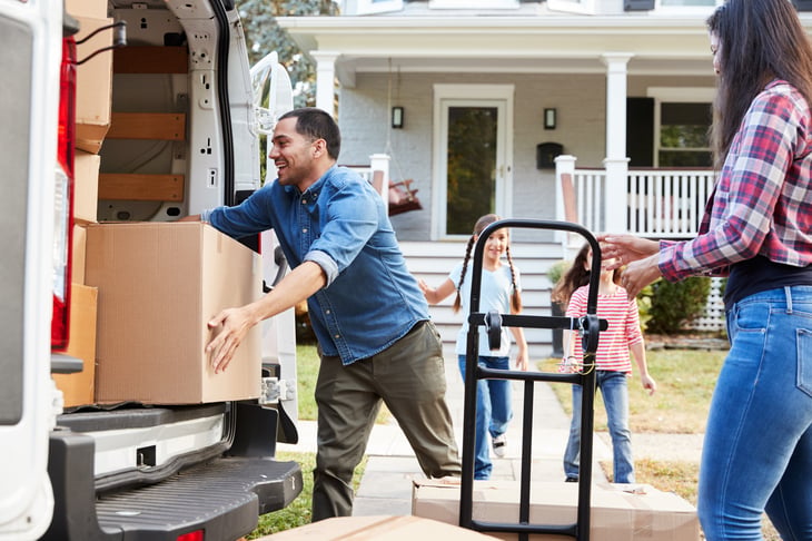 A family unloads a moving truck