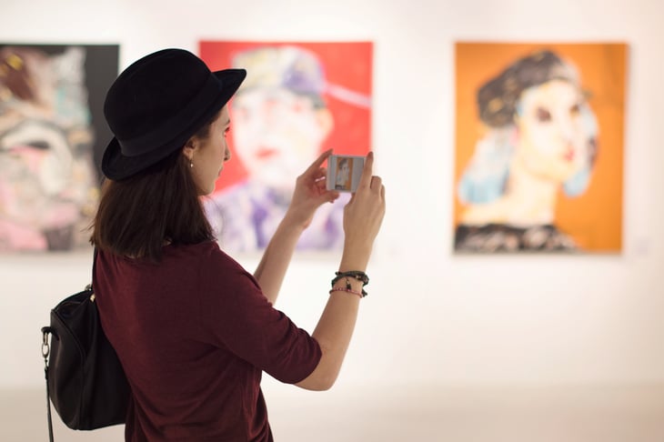 A woman takes pictures at an art gallery