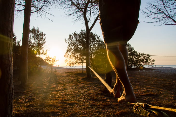 Person walking on slackline at beach