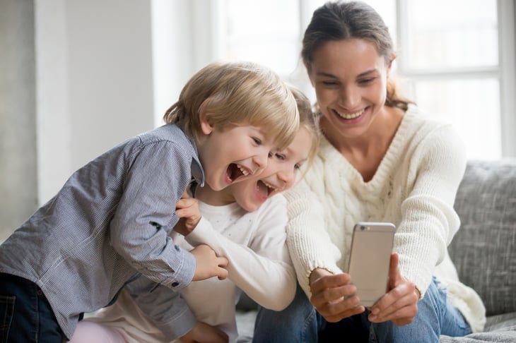 Woman and children looking at cellphone