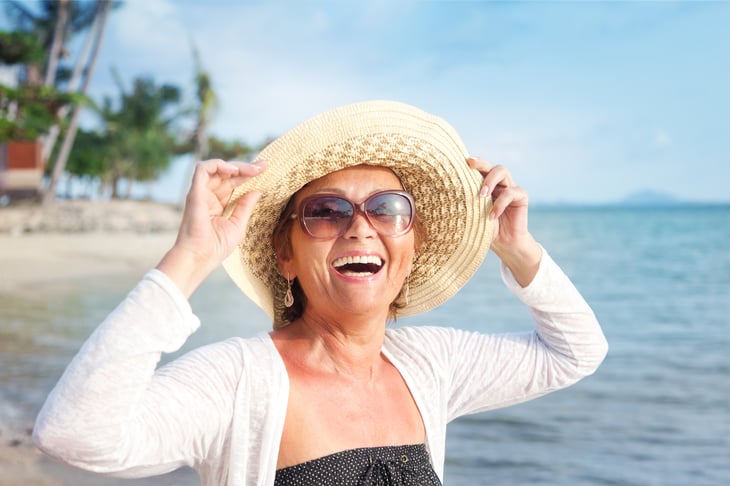 Woman in sunhat on beach.