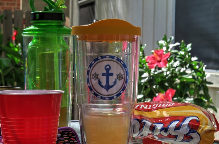 Summer Picnic Barbeque Table Items Including a Frito's Bag and Tervis Drink Glass on an Outdoor Table