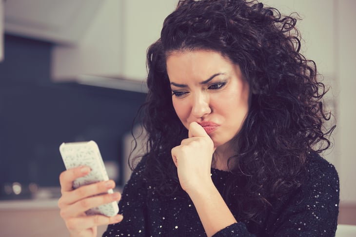 Woman looking stressed, looking at cellphone