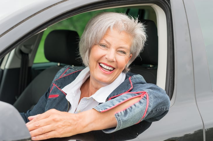 Woman at wheel of car.