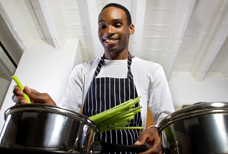 Young African American man cooking.