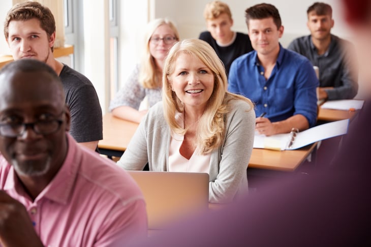An older student sits in a college classroom